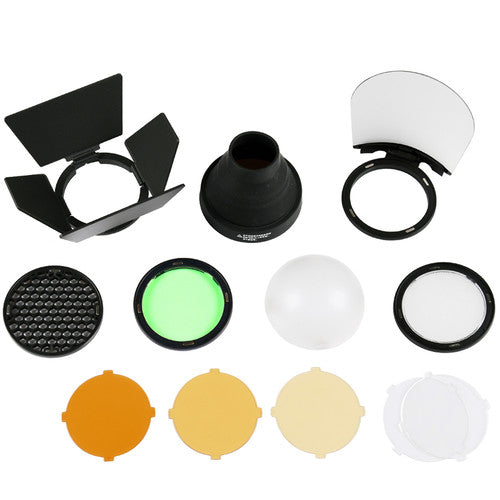 A collection of various photography accessories including a diffuser dome, warming filters, a filter holder, a green filter, a honeycomb grid, a snoot, a four-way barndoor set, and a bounce card with a frame.