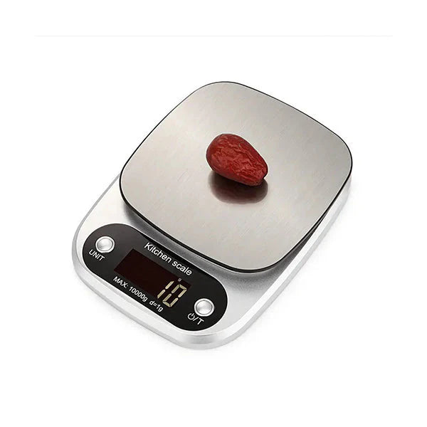 A digital kitchen scale with a silver platform and black control panel, displaying a small red object on top.