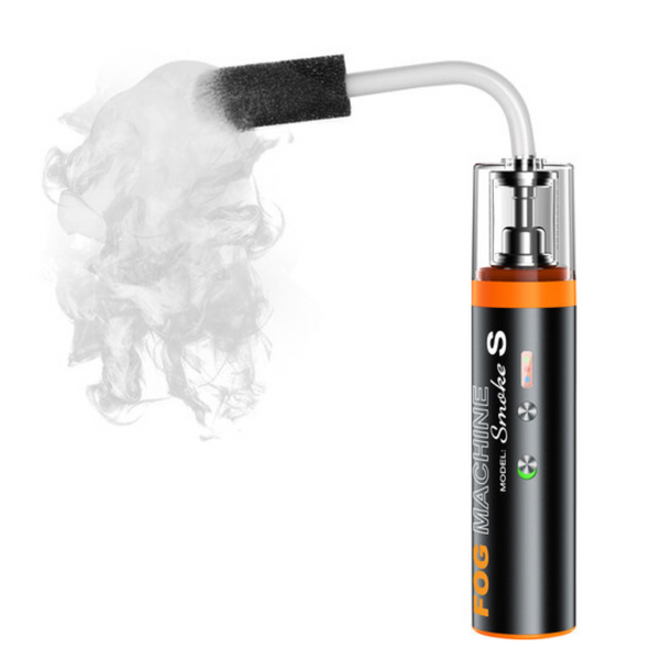 A portable black fog machine with an orange label, emitting smoke, designed for creating special effects for photography and videography.