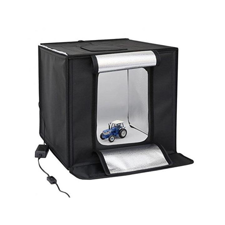 A black portable light box with a white interior, featuring a small toy car on the floor, with hook-and-loop fasteners and a power supply attached.