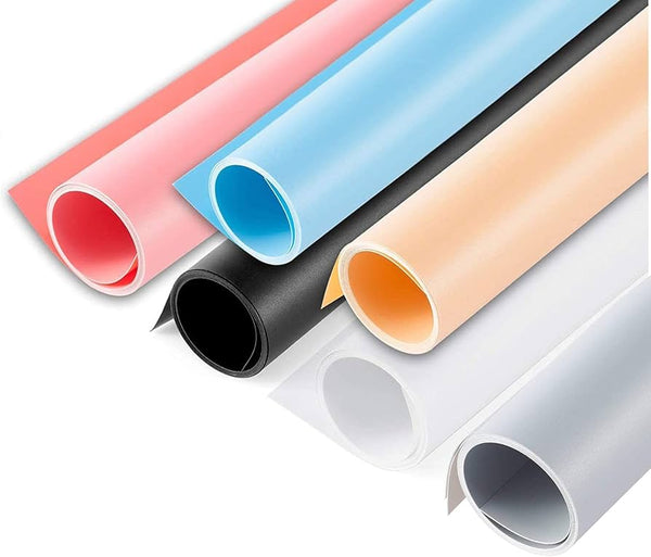 Rolls of PVC background paper in various colors including black, white, grey, blue, pink, red, orange, and green, typically used for product photography.