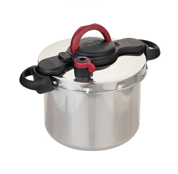 Stainless steel pressure cooker with black and red lid on a white background